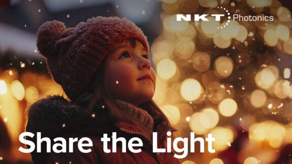 Small child in winter clothes looking at Christmas lights